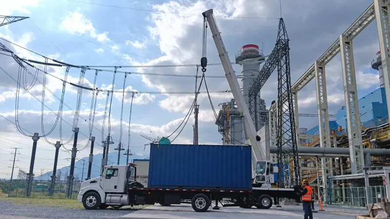 Grúa telescópica de 50 toneladas cargando un contenedor sobre una plataforma junto a una subestación eléctrica en Carmen, Nuevo León