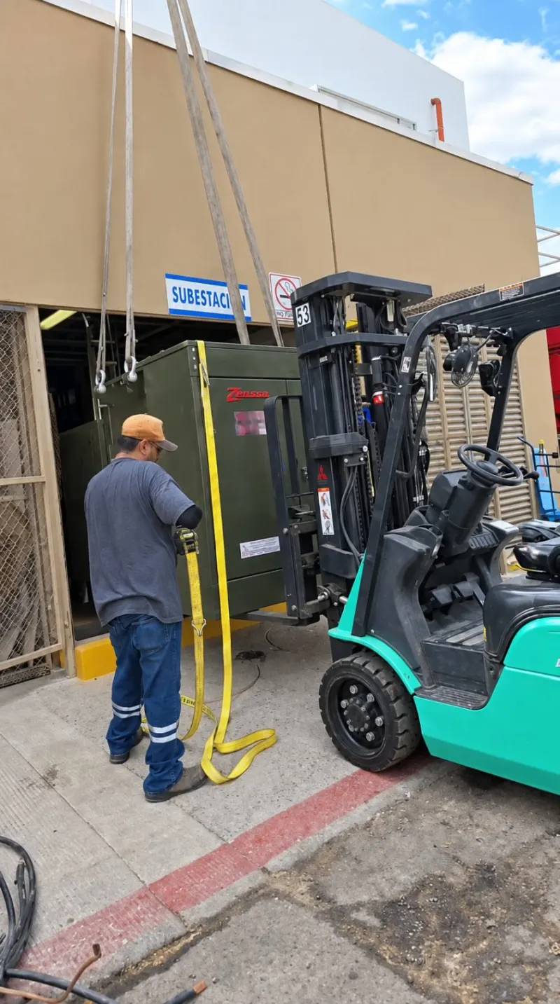 Montacargas introduce un transformador por el acceso enrejado de la subestación.